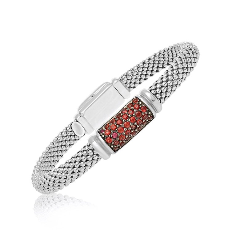 Designer Ruby Popcorn Style Bangle Bracelet: Popcorn motif bangle features a section with ruby accents and polished border detailing. Crafted in white gold rhodium bonded sterling silver and comes in size 7 1/4".
