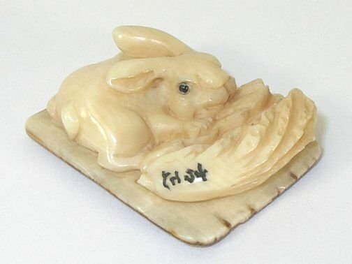 Rabbit Hand Carved Ivory Netsuke Figure: Hand Carved Ivory Netsuke Figure depicting a rabbit. Measures 1 " L. Signed.