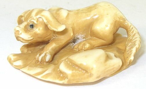 Dog Hand Carved Ivory Netsuke Figure: Hand Carved Ivory Netsuke Figure depicting a dog. Measures 1.25" L. Signed.