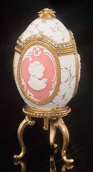 Decorative Swarovski Crystal Cameo Jeweled Egg: A delicate white leaf pattern meticulously carved into the shell creates a lace effect on this stunning egg. Three oval cameo panels grace the sides of the egg, each of which features an ivory-colored