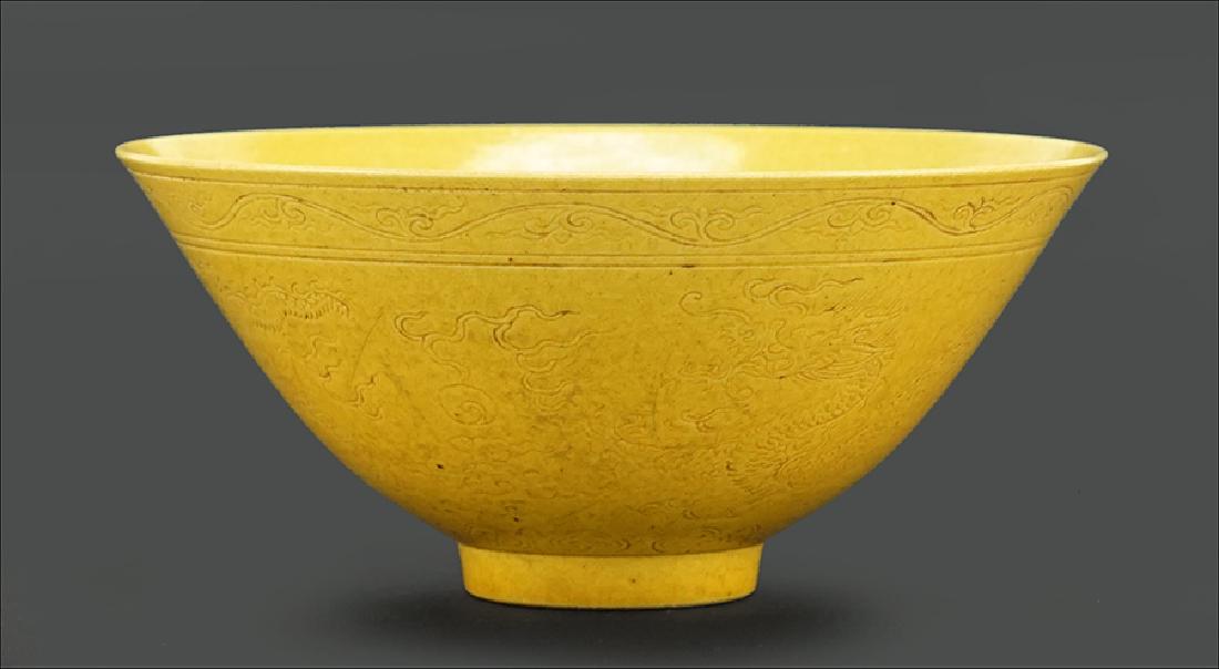 A Chinese 19th Century Yellow Glazed Porcelain Bowl.: A Chinese 19th Century Yellow Glazed Porcelain Bowl. With an incised dragon and flaming pearl motif to the exterior perimeter and a symbol to the interior bed. Bearing a six-character Tongzhi mark on 