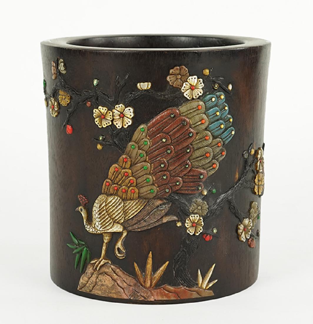 A Chinese Hardwood Brush Pot.: A Chinese Hardwood Brush Pot. Bearing an applied abalone and hardstone peacock with flowering branch decoration and an applied bone inscription, signed and with seal 6.75" x 6.5"