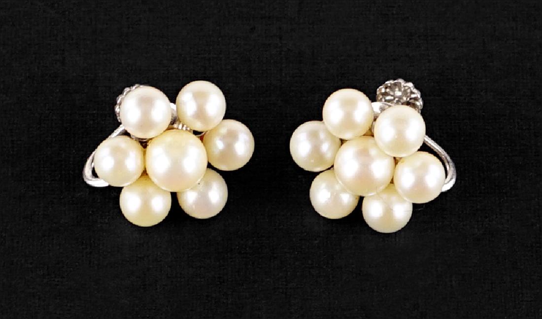 A Pair of Pearl Earrings.: A Pair of Pearl Earrings. 14 karat white gold screwback earrings each contain seven cream cultured pearls designed as a flower blossom Diameter: 18mm