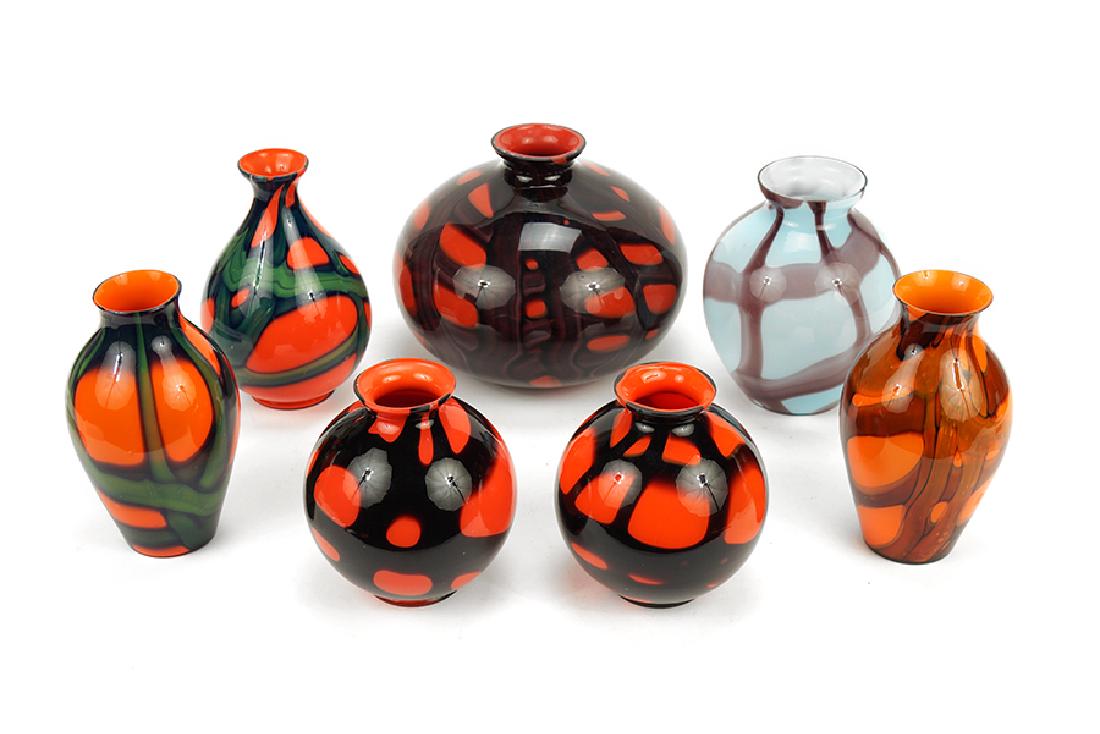 A Collection Of Czech Glass Vases.: A Collection Of Czech Glass Vases. Comprising a near pair of orange vases with black decorations, two orange vases with green decorations, a light blue vase with purple decorations, and two orange vas