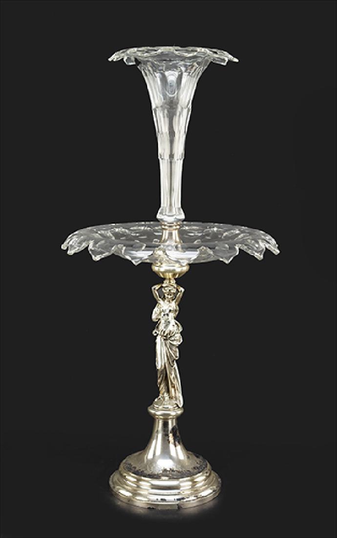 A Figural Silverplate And Glass Epergne.: A Figural Silverplate And Glass Epergne. Crystal trumpet vase atop a bowl on a caryatid form support Height: 30"