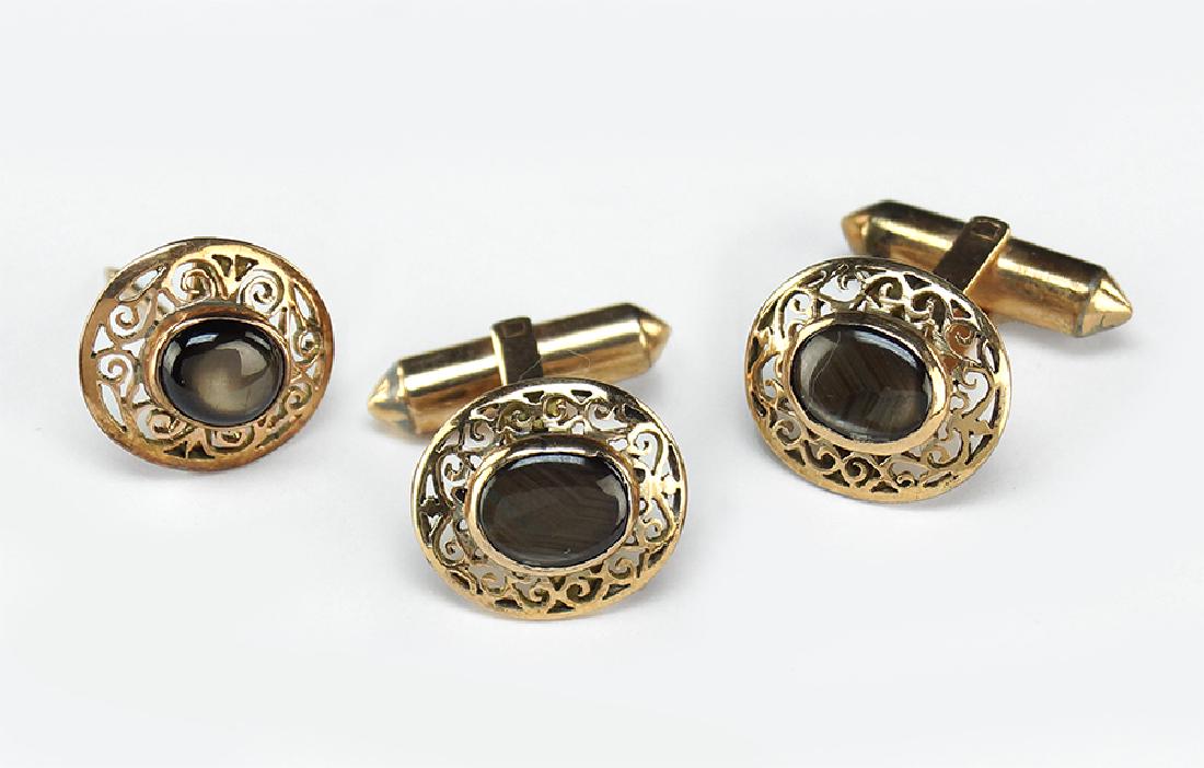 A Suite of Men's Black Star Sapphire Jewelry.: A Suite of Men's Black Star Sapphire Jewelry. Comprising a pair of cufflinks and a tie tack. Cufflink mountings are 14 karat and 10 karat gold Wt: 8.1 grams
