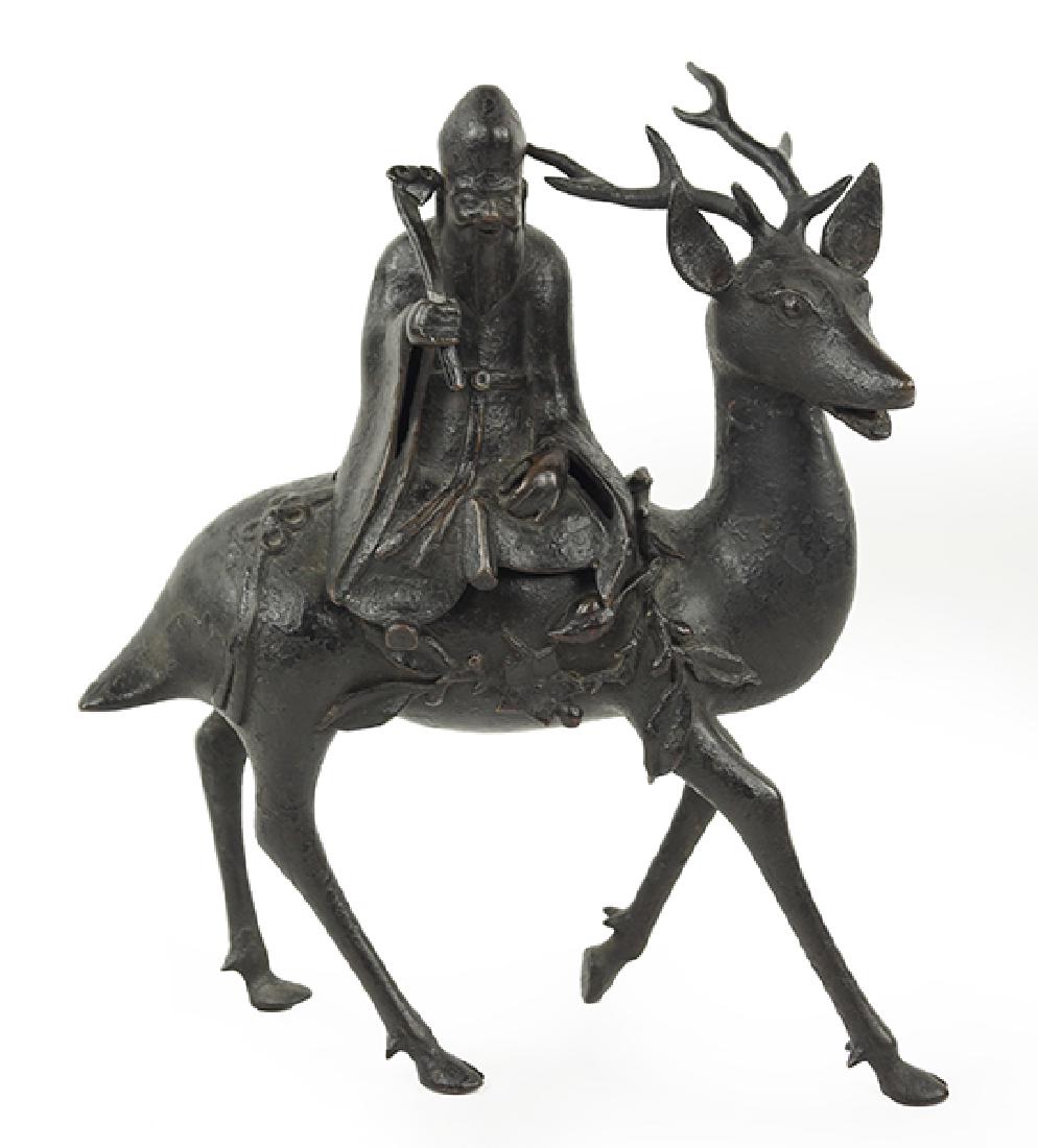 A Patinated Metal Incense Burner.: A Patinated Metal Incense Burner. Depicting Shoulao holding a scepter in his right hand, while seated atop a deer 10" x 8" x 3"