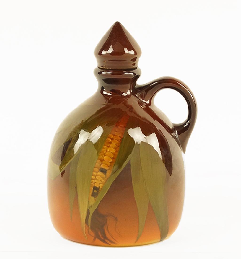 A Rookwood Jug.: A Rookwood Jug. Stoppered jug decorated with corn and leaves. Underside is stamped LNL for Elizabeth N. Lincoln, and 747C Height: 7.25"