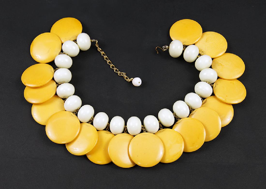 A Bakelite Necklace.: A Bakelite Necklace. Cream bead necklace with yellow bakelite round pendant charms Length: 17"