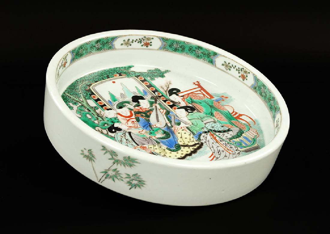 A Chinese Famille Verte Porcelain Low Bowl.: A Chinese Famille Verte Porcelain Low Bowl. Bearing an outdoor scene with figures playing instruments in the bed, bamboo on the outer rim, and an underglaze blue Kangxi mark within double blue rings o