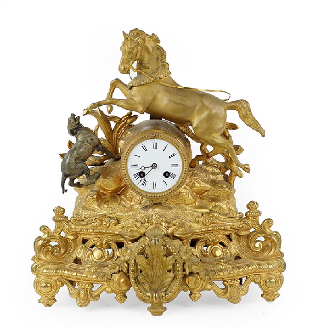 A Gilt Metal Mantle Clock.: A Gilt Metal Mantle Clock. Depicting a rearing horse and hunting dog above a Rococo style base. With pendulum and key. Susanin's will not comment on the working condition of any watch or clock movemen