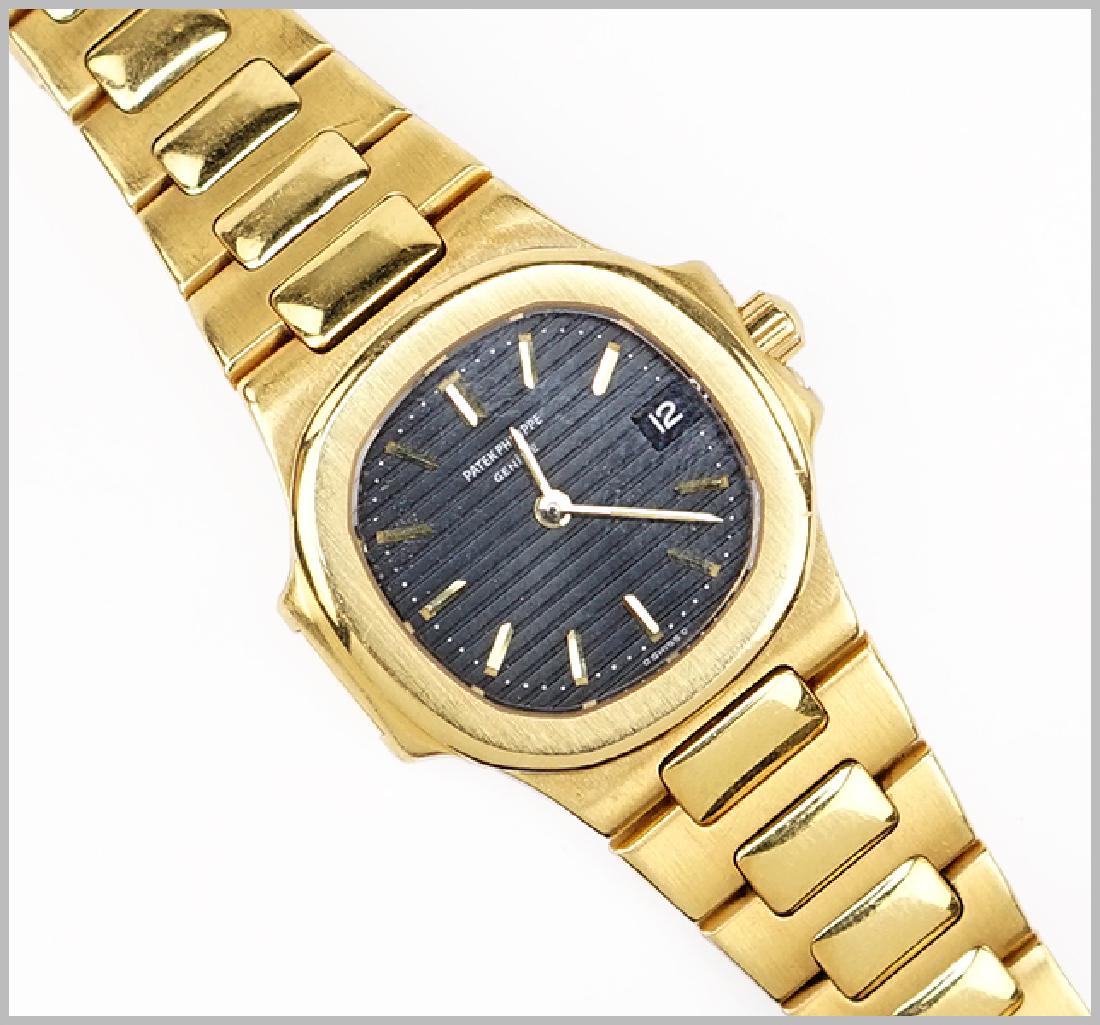 A Patek Philippe Lady's Nautilus Watch.: A Patek Philippe Lady's Nautilus Watch. 18 karat yellow gold lady's watch with a horizontal striped charcoal gray dial and baton hands. Reference 4700. Bracelet stamped "Nautilus Patek Philippe Geneve