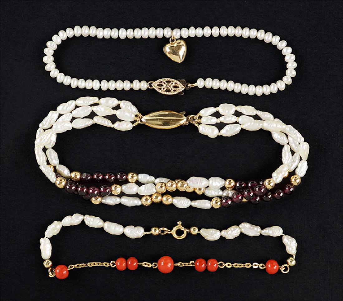 Three Pearl Bracelets.: Three Pearl Bracelets. Comprising a coral bead, freshwater pearl and 18 karat yellow gold bracelet, a seed pearl and 14 karat yellow gold bracelet, and a freshwater pearl, garnet bead and 14 karat yel