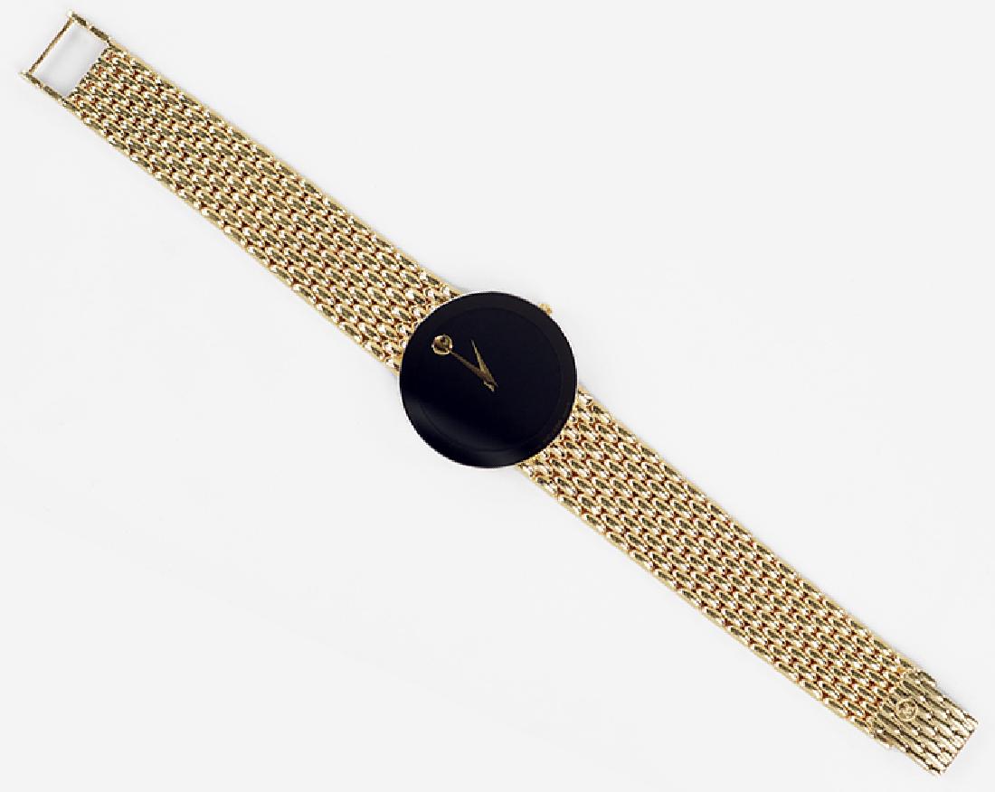 A Movado 14 Karat Yellow Gold Watch.: A Movado 14 Karat Yellow Gold Watch. Black dial and bezel with a quartz movement. Reverse of case is stamped "70-40-882E89 1142478". 14 karat yellow gold bracelet and buckle are original to watch. Sus