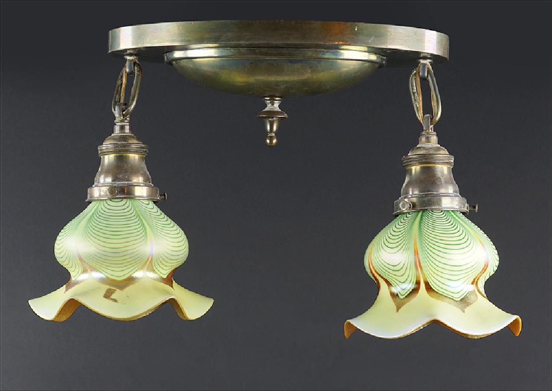 An Oval Brass Ceiling Mount Two-Light Fixture.: An Oval Brass Ceiling Mount Two-Light Fixture. Together with two pulled feather and gold glass shades in the style of Quezal (4.75" x 5.75") 12.5" x 6.5" x 6"