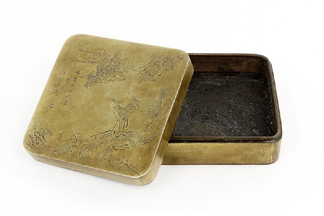 A Chinese Bronze Inkstone Box.: A Chinese Bronze Inkstone Box. Decorated with a landscape and cranes, bearing an inscription on the lid 1 5/8" x 4 1/2" x 4 1/2"