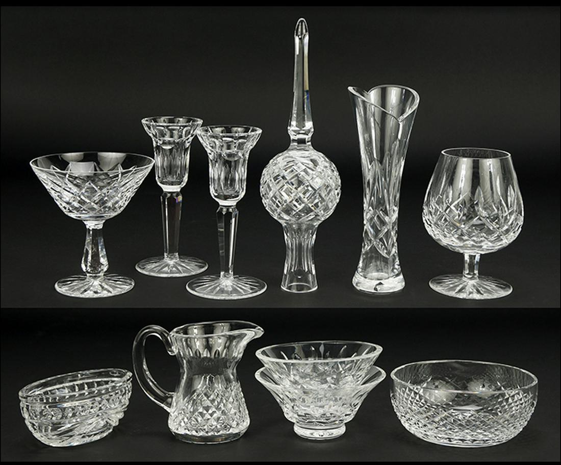 A Collection of Waterford Crystal Table Articles.: A Collection of Waterford Crystal Table Articles. Comprising a pair of candlesticks, a pair of footed bowls, a tree topper, a snifter, a bowl, a footed compote, a creamer, a bud vase, and an oblong di