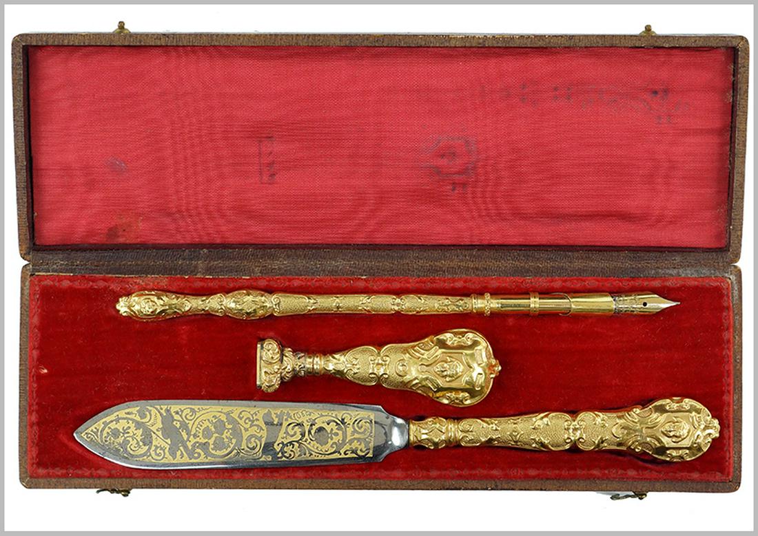 A Victorian Writing Set.: A Victorian Writing Set. Gold filled writing set comprising a dip pen with 14k gold plated nib, a letter opener, and a monogrammed seal. With fitted box Letter Opener: 7.5"