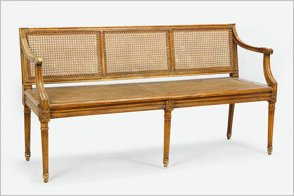 A 19th Century Settee.: A 19th Century Settee. Louis XVI style carved wood settee with caned seat and backrest 30" x 59" x 18"