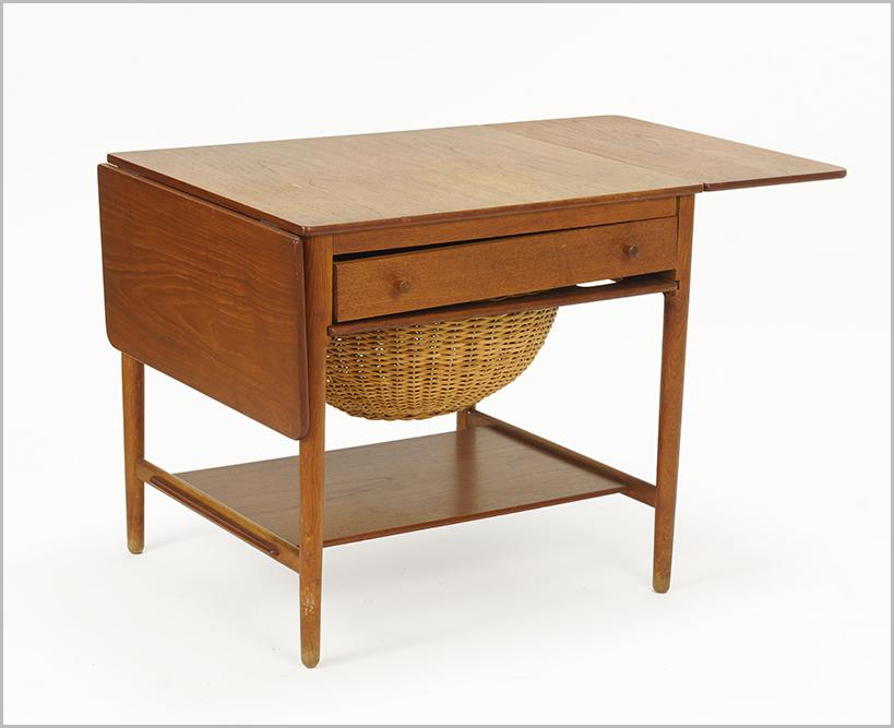 A Hans Wegner Teak Sewing Table.: A Hans Wegner Teak Sewing Table. Drop leaf table with drawer for threads / bobbins and pull out basket beneath. Underside reads "Fabrikat: andr. Tuck Arkitekt; Hans J. Wegner Denmark Made in Denmark"