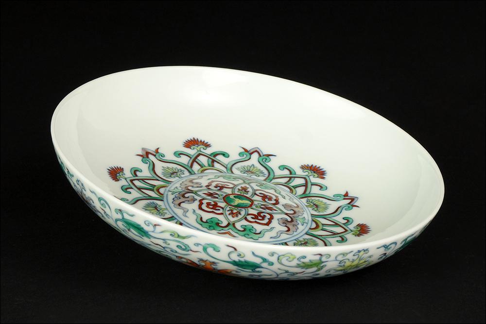 A Chinese Doucai Glazed Porcelain Dish.: A Chinese Doucai Glazed Porcelain Dish. Bearing an intricate foliate pattern throughout, with a slightly raised bed and an underglaze blue Yongzheng mark within double blue rings on the underside 1.5"