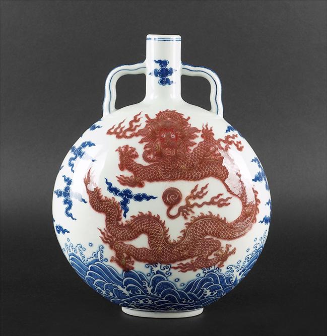 A Chinese Porcelain 'Dragon' Moon Flask.: A Chinese Porcelain 'Dragon' Moon Flask. Underglaze blue and iron red decoration of a dragon, clouds, and waves. Bearing an underglaze blue archaic Qianlong mark on the underside 12.75" x 9.75" x 5.5"