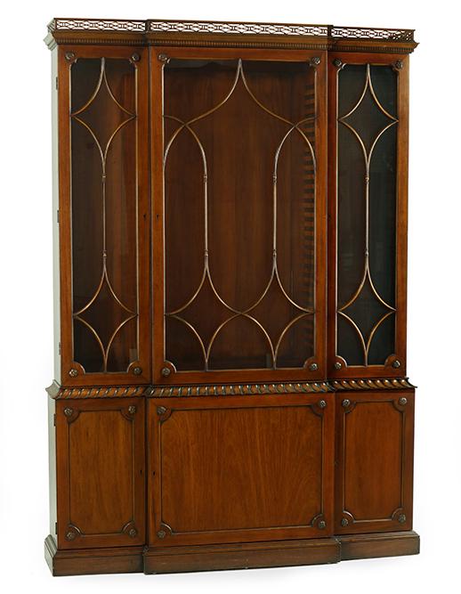 A Kittinger Mahogany Breakfront.: A Kittinger Mahogany Breakfront. Bearing fretwork at the crown, carved rosettes on the doors, and with adjustable shelving 94" x 60" x 14"