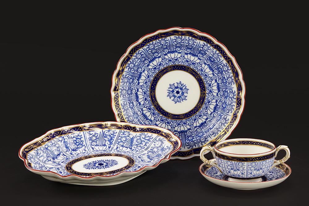 A Collection of Royal Worcester Porcelain Dinnerware in: A Collection of Royal Worcester Porcelain Dinnerware in the Royal Lily Pattern. Including a set of six double handled bouillon cups and saucers (marked for Tiffany & Co.), a set of eight scallop edge 