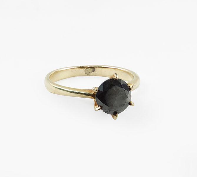 A Black Diamond Ring.: A Black Diamond Ring. 10 karat yellow gold mounting contains one prong set round black diamond which is approximately 1.25 carats Size: 4.5 Wt: 1.8 grams