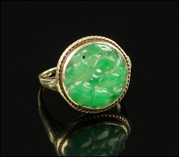 A Jadeite Ring.: A Jadeite Ring. 14 karat yellow gold mounting contains one bezel set carved jadeite plaque Size: 6 Wt: 3.2 grams