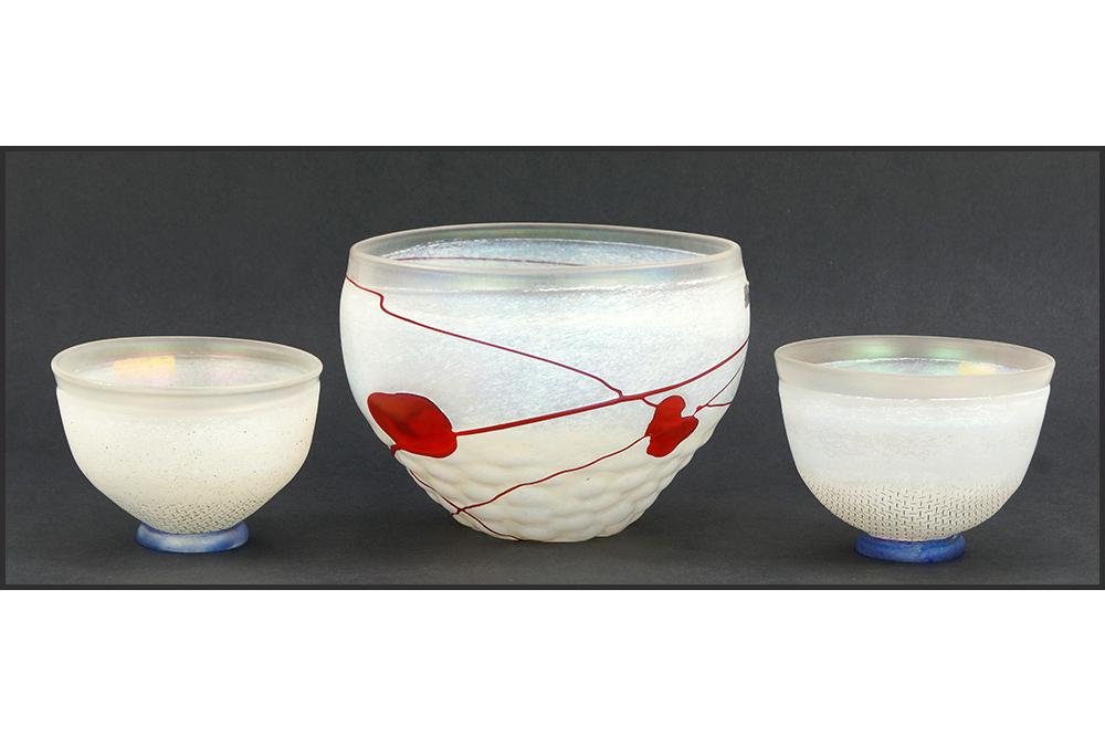 Three Bertil Vallien for Kosta Boda Glass Bowls.: Three Bertil Vallien for Kosta Boda Glass Bowls. Comprising a glass bowl with red decoration and two smaller bowls with blue bases Largest bowl: 5" x 6.75"