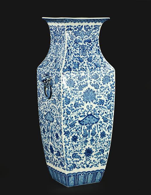 A Chinese Blue and White Porcelain Squared Vase.: A Chinese Blue and White Porcelain Squared Vase. Bearing foo lion form handles, an intricate decoration of flowers, bats, and symbols, and an underglaze blue archaic Qianlong mark on the underside Hei