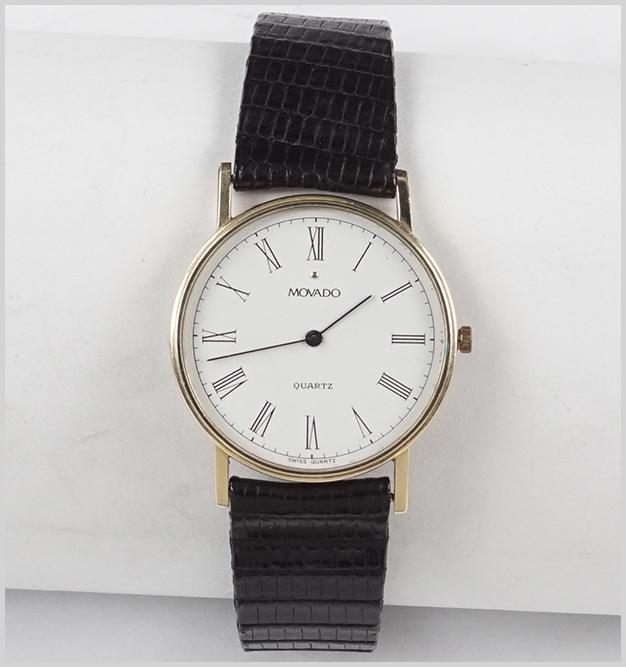 A Movado Watch.: A Movado Watch. 14 karat yellow gold case contains a replacement quartz movement. Reverse of case is engraved "The Girl / The Gold Watch / And / Everything". Case is numbered 7833885 54050". Bracelet