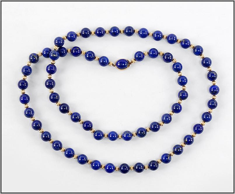 A Lapis Necklace.: A Lapis Necklace. Alternating lapis beads (10mm) and fluted 14 karat yellow gold beads (4mm) with a lapis and 14 karat yellow gold clasp Length: 33" Wt: 94 grams