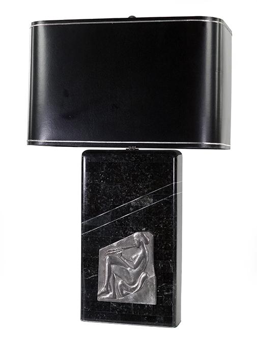 A Deco Style Tessellated Table Lamp.: A Deco Style Tessellated Table Lamp. Stone veneered two-light lamp bearing a metal relief medallion of a nude playing the flute Height to top of base: 16"