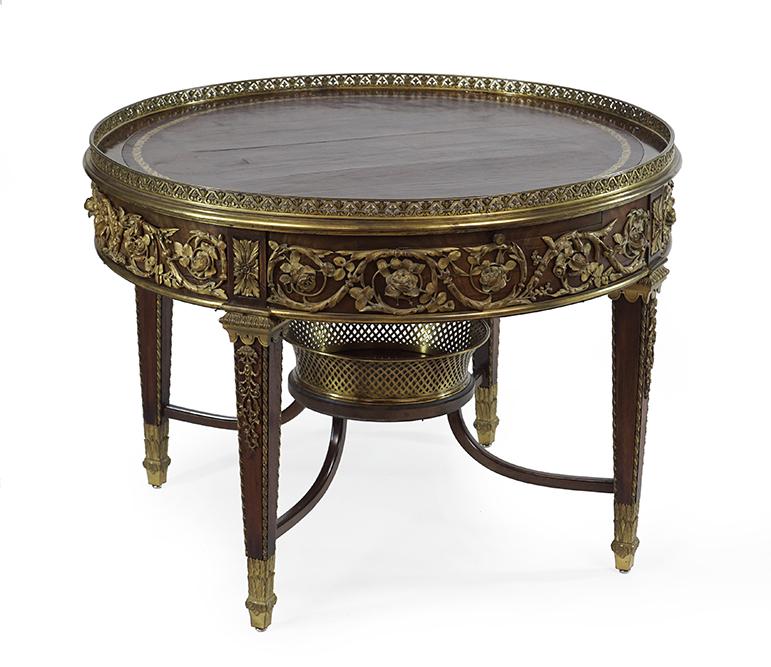 A Louis XVI Style Ormolu Mounted Mahogany and Leather: A Louis XVI Style Ormolu Mounted Mahogany and Leather Library Table. With a brass gallery ledge, ornamental foliate form mounting along the perimeter, and two drawers and two slide outs. The lower cen