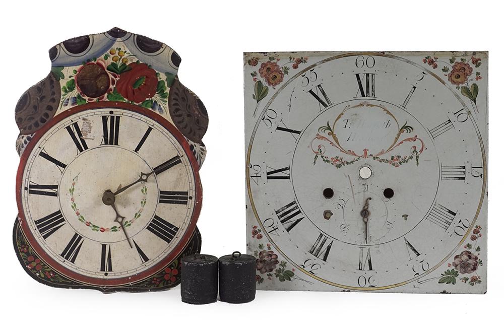 A 19th Century Wag-on-the-Wall Clock.: A 19th Century Wag-on-the-Wall Clock. Painted wood clock face with Roman numerals and flowers, with weights. Together with a painted metal clock face with both Arabic and Roman numerals, decorated wit