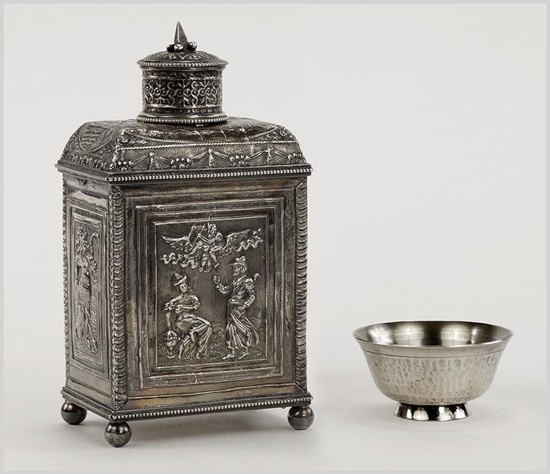 A Silver Tea Caddy.: A Silver Tea Caddy. Decorated with relief panels on all four sides and raised on ball feet. Together with a Chinese silver salt cellar Tea caddy: 5" x 2 12" x 1 3/4" Wt of both: 5.10 ozt