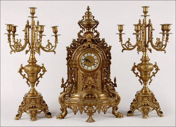 GERMAN GILT METAL CLOCK AND GARNITURE.: GERMAN GILT METAL CLOCK AND GARNITURE. Clock movement by Franz Hermle & Sons Clock: 24" x 14" x 7" Candelabra: 23.5" x 12"