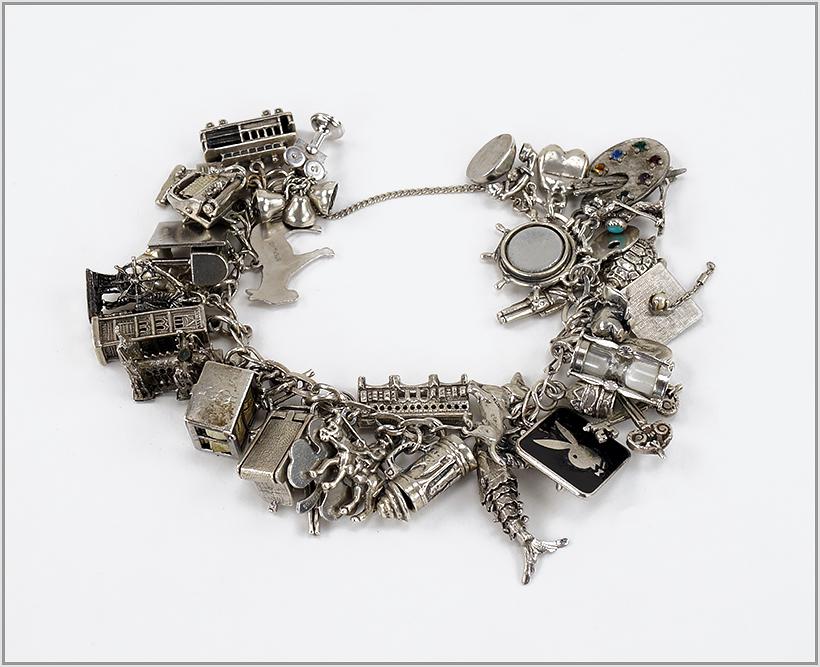 A Sterling Silver Charm Bracelet.: A Sterling Silver Charm Bracelet. Silver link bracelet mounted with many sterling silver charms Length: 6 3/4" Wt: 120 grams