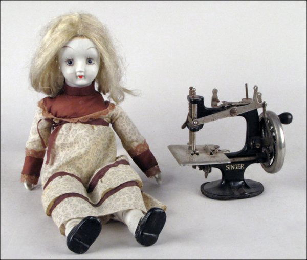 CHILD'S SINGER SEWING MACHINE.: CHILD'S SINGER SEWING MACHINE. Together with an unmarked doll with painted porcelain face, hands, and feet Sewing machine: 6.5" x 7" Doll: 17.5"