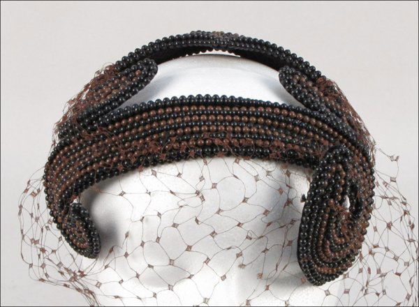 BES-BEN BEADED HAT.: BES-BEN BEADED HAT. Bandeau is entirely covered in brown and black beads, with a brown veil