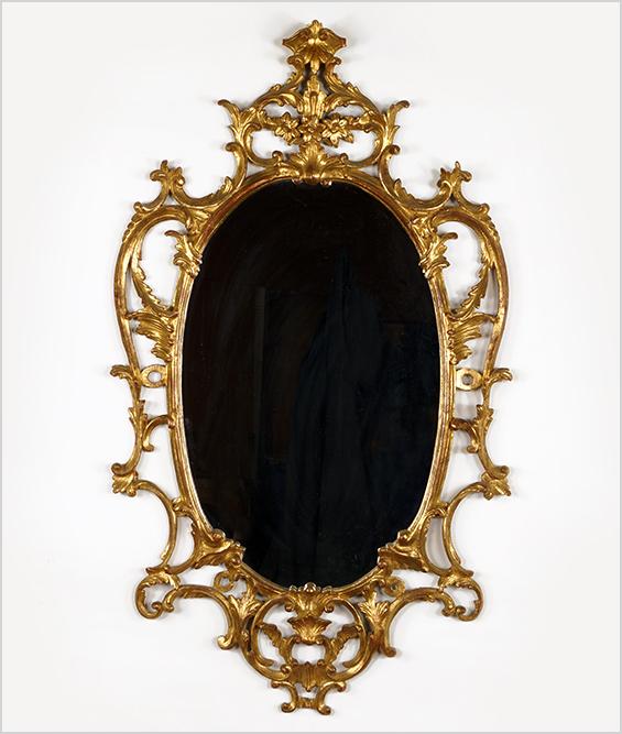 A 19th Century George III Style Mirror.: A 19th Century George III Style Mirror. Gesso and giltwood oval mirror with flowers and swags throughout 48" x 27"
