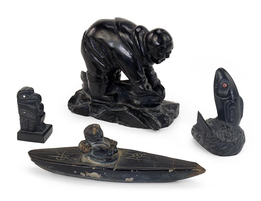 Three Argillite Carvings.: Three Argillite Carvings. Comprising a seated eagle signed "Kevin Ryland 2000", a fish, and a hunter killing a seal; unsigned. Together with an Inuit stone carving of a figure in a boat (length: 7") L