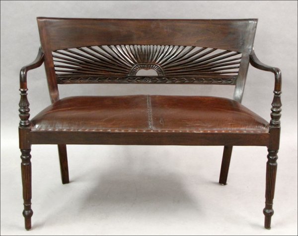 CARVED MAHOGANY SETTEE WITH A LEATHER UPHOLSTER: CARVED MAHOGANY SETTEE WITH A LEATHER UPHOLSTERED SEAT. H: 32" W: 42" D: 16"