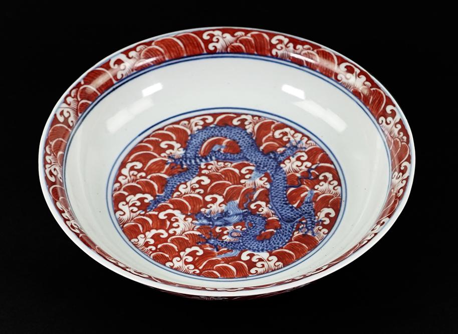 A Chinese Blue and White Porcelain Low Bowl.: A Chinese Blue and White Porcelain Low Bowl. Bearing a decoration of a dragon to the interior, fish and qilin to the exterior and overglaze red waves. With an underglaze blue six-character Ming mark w