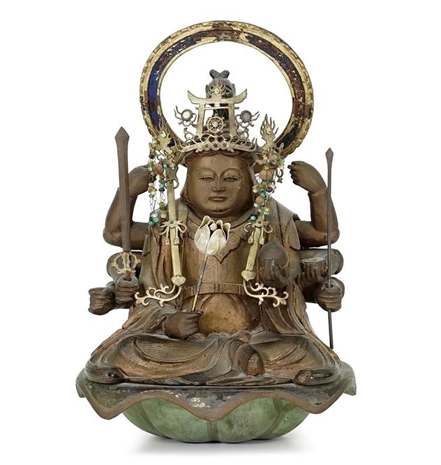 A Seated Buddha.: A Seated Buddha. Gilt and painted carved wood seated Buddha with eight arms. Figure is depicted with objects in hands and wearing a metal and beaded headdress. Figure is seated atop a lotus base Buddh