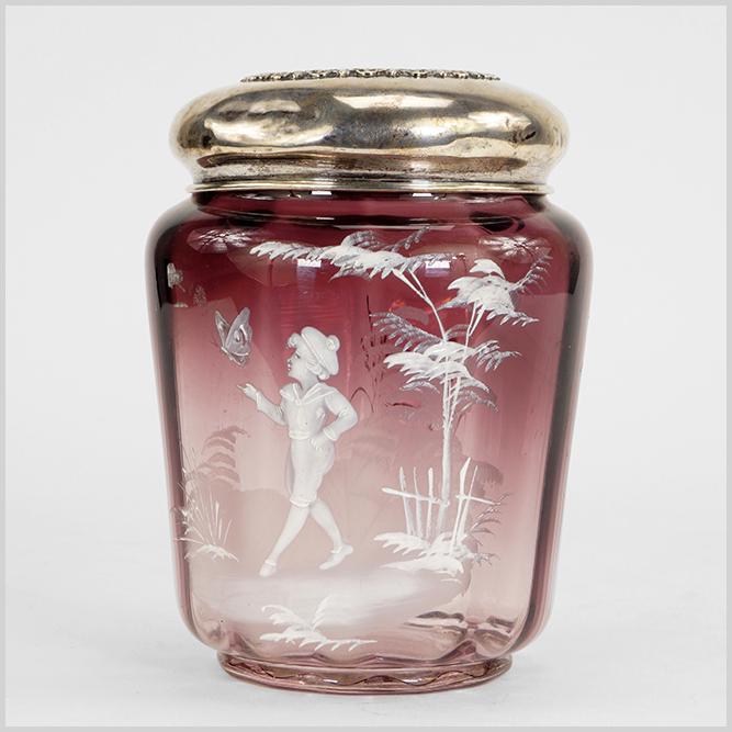 Victorian Amethyst Glass Mary Gregory Biscuit Jar.: Victorian Amethyst Glass Mary Gregory Biscuit Jar. Featuring an amethyst glass biscuit jar decorated in the style of Mary Gregory with a sterling silver lid Height: 7"