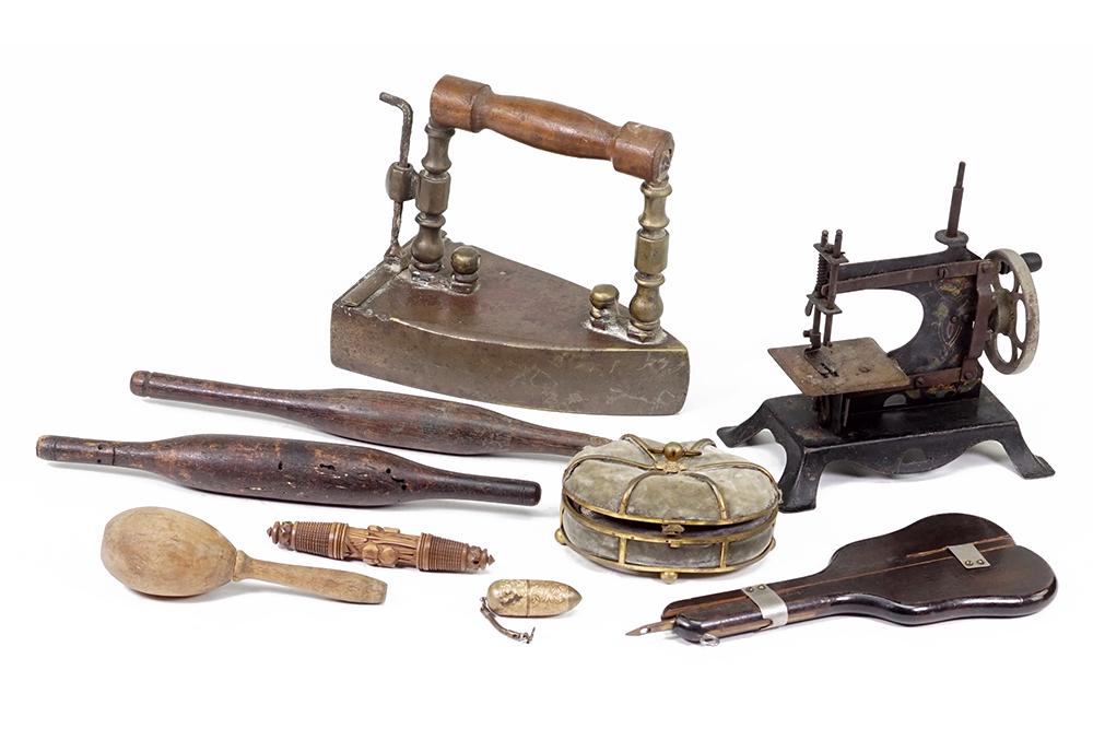 A Group of Antique Sewing Items.: A Group of Antique Sewing Items. Consisting of needle cases, yarn spools, toy sewing machine, pin cushion, sock darner, iron and a yarn shuttle Iron: 7" x 4 1/2"