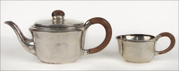 WALTER KLEIN FOR GEBRUDER KUHN 835 SILVER HAND HAMMERED: WALTER KLEIN FOR GEBRUDER KUHN 835 SILVER HAND HAMMERED TEAPOT WITH WOOD HANDLE AND FINIAL. Together with matching creamer, c. 1920